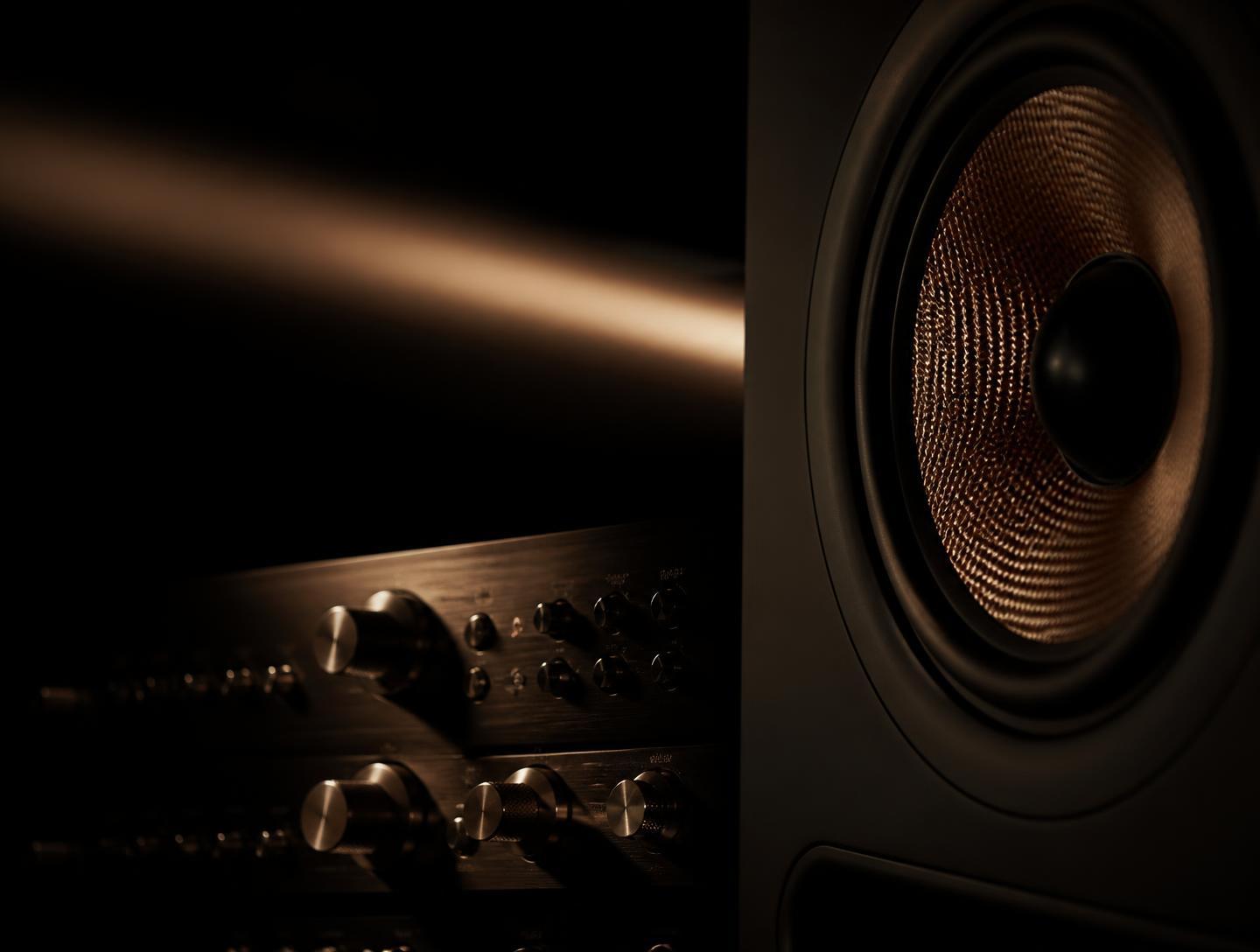 Studio monitor and outboard rack gear lit by a single warm light